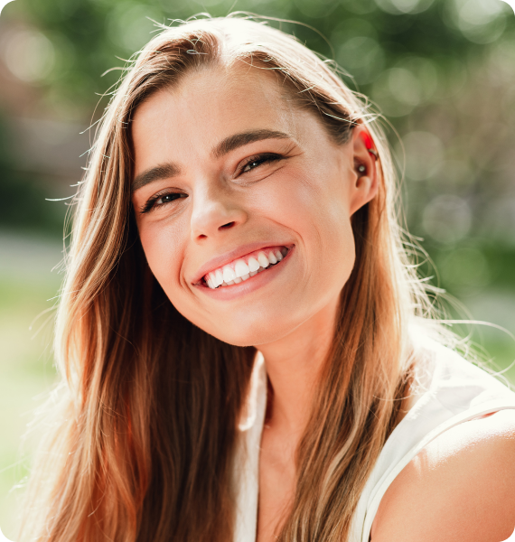 Smiling woman outside with healthy teeth